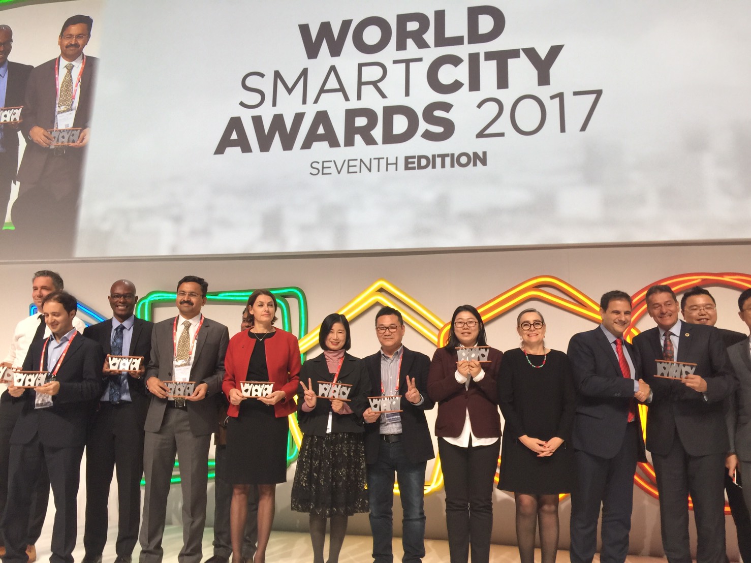 圖說：台北市路燈實證計畫獲「World Smart City Awards 2017」入圍專案奬項，資訊局陳慧敏主任秘書(圖左6)、中華系統整合代表(圖左7)上台領獎