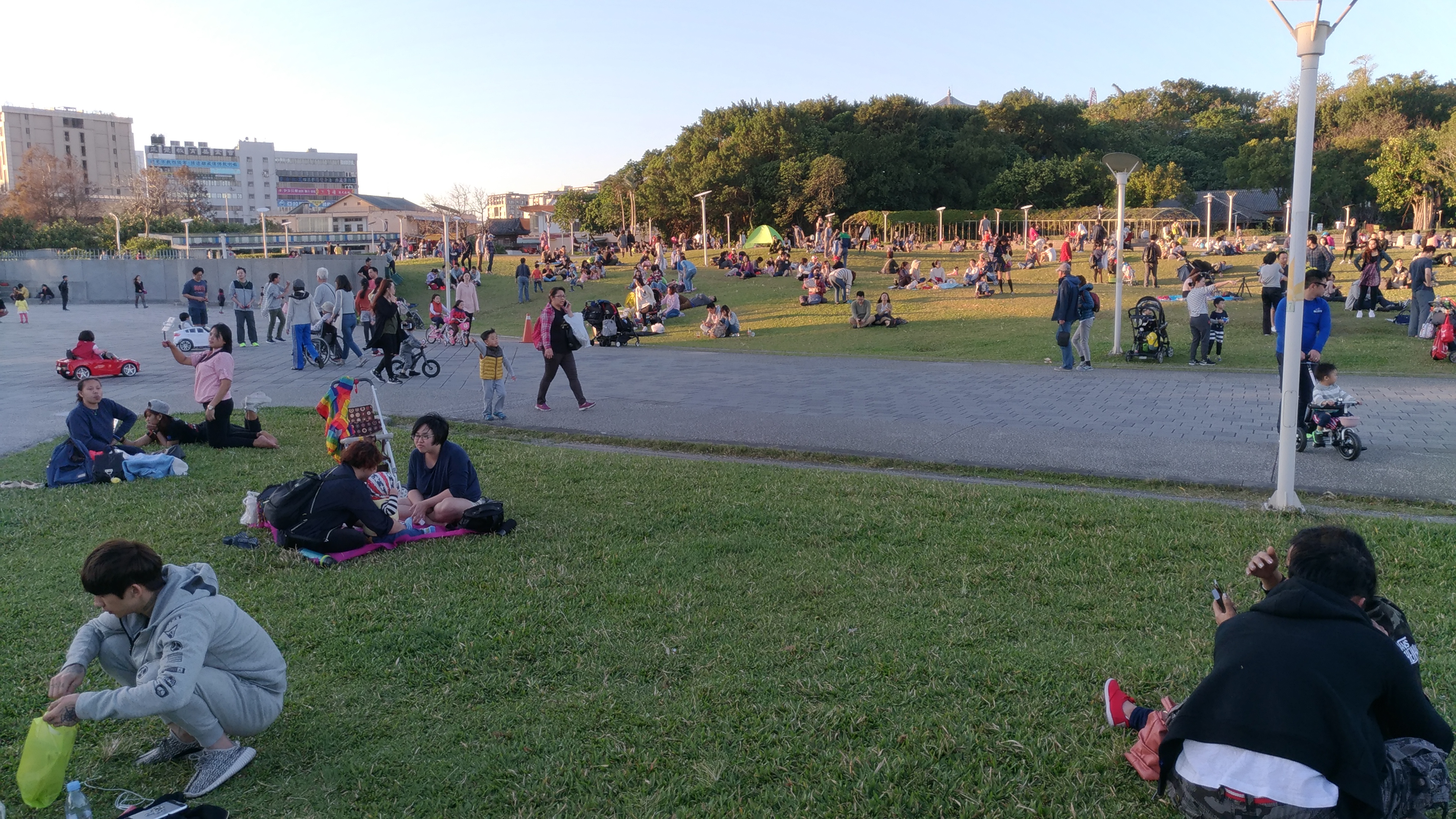 圖8、花博圓山園區在翠綠青草上聊天休憩的大人們及奔跑的小孩。