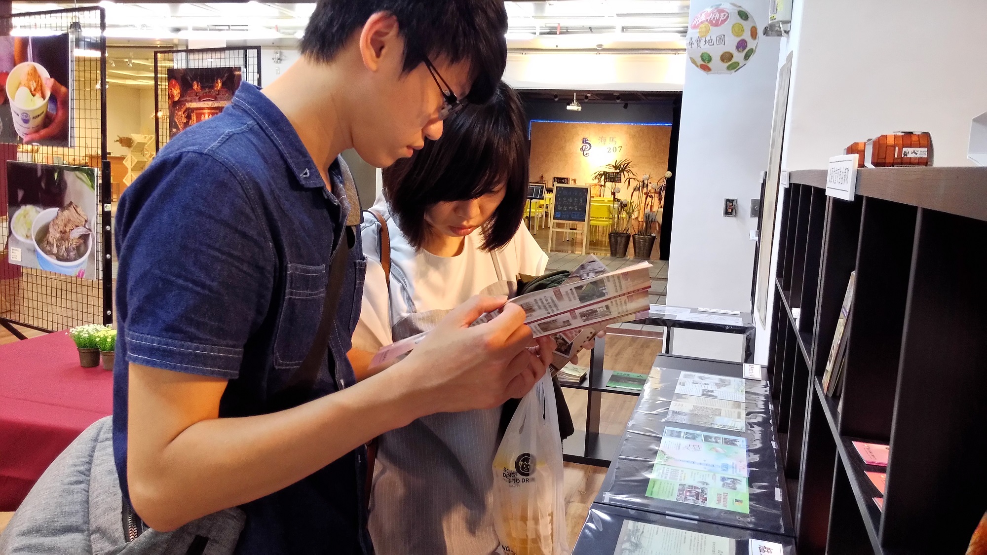 民眾於特展現場翻閱文宣品及旅遊導覽手冊