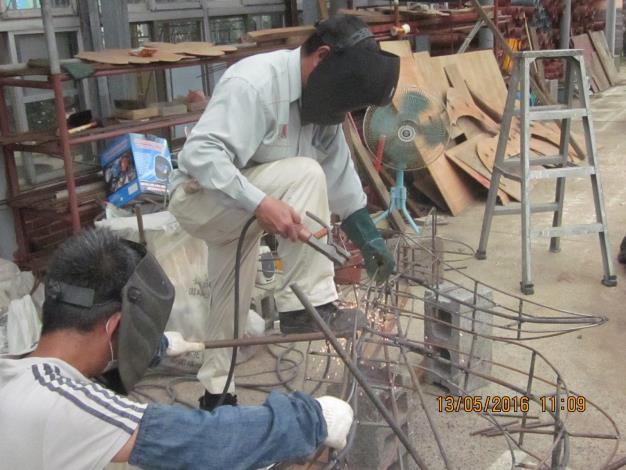 圖1.同仁們刻正進行極傷眼力的綠雕骨架焊製工作