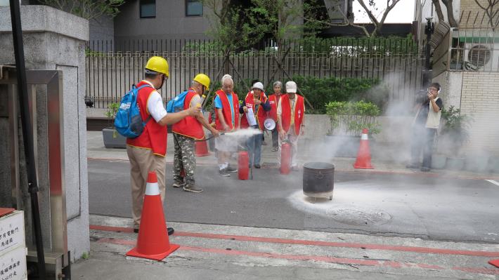 圖11：自主防災成員於發生火災時緊急以滅火器撲滅火勢。