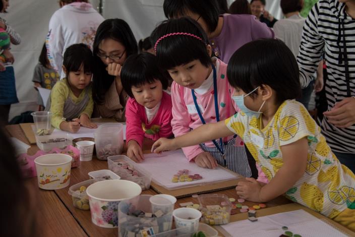 圖6 兒童專心地擺放磁磚於創作紙板上，創作出獨一無二的作品