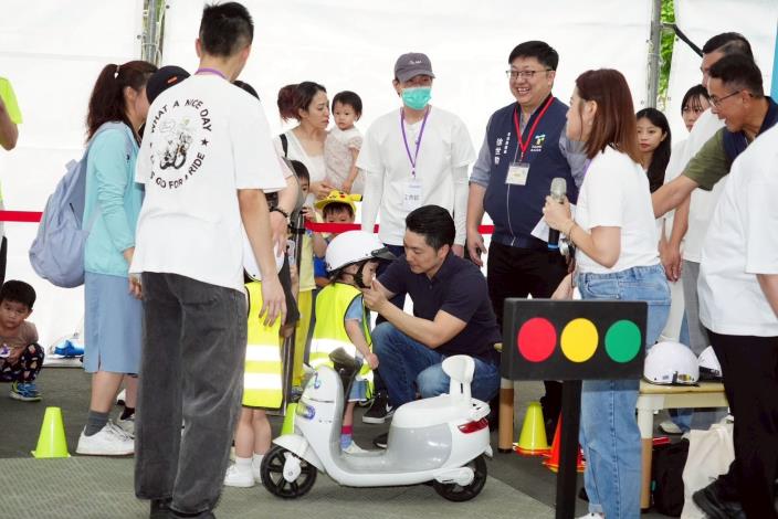 蔣萬安出席115年地球日活動為騎電動車的小朋友戴上安全帽