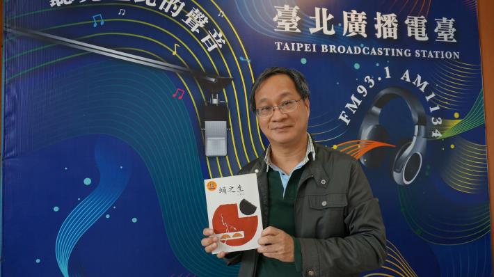作家小野接受臺北廣播電臺專訪，開心地和自己的作品「蛹之生」合照。
