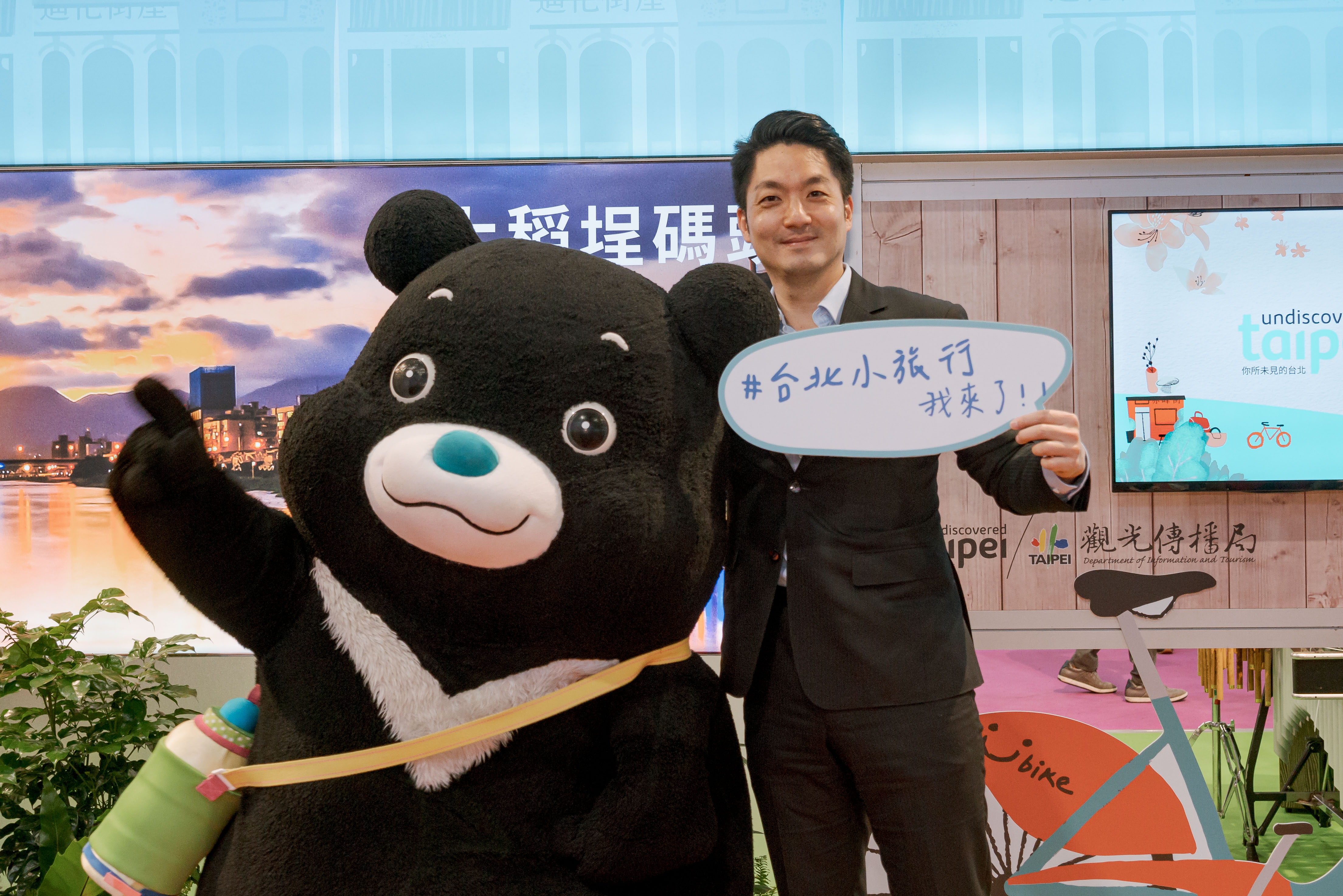 臺北市長蔣萬安蒞臨臺北館，與臺北市吉祥物熊讚於舞台區合照。