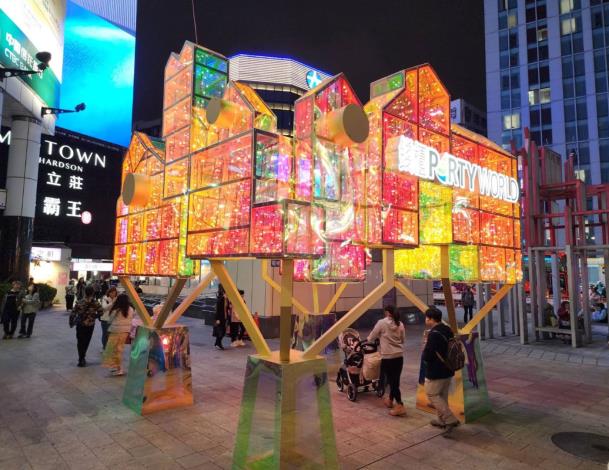 錢櫃「不夜城」以金光閃閃的城市模型象徵美麗閃耀的臺北故事，燈組底部通道還可供民眾穿梭駐足。