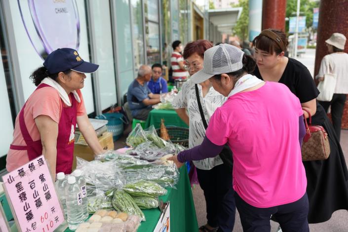 民眾在小農市集認真挑選當季蔬菜.JPG
