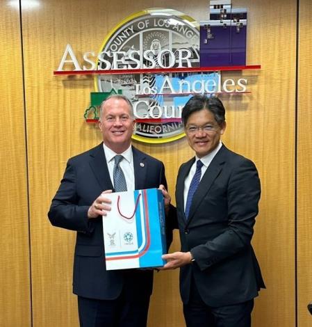 Commissioner You presented County Assessor Prang with promotional souvenirs for the 2025 World Master Games.