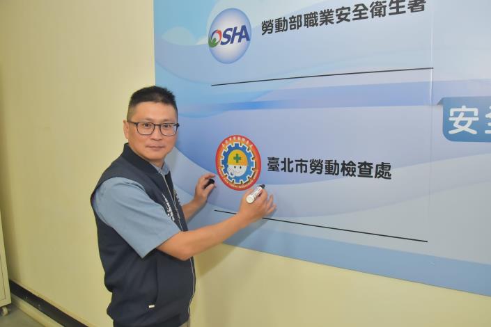 Director Ho Hung-cheng of the Taipei City Labor Inspection Office signing the declaration