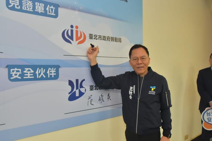 Commissioner Wang Chiu-tung of the Taipei City Department of Labor signing the declaration