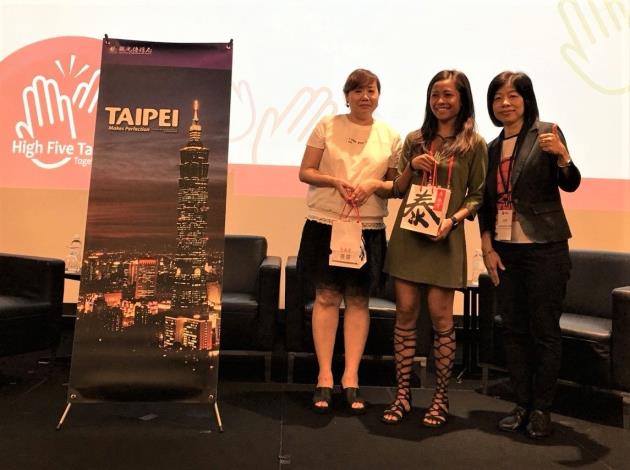 Lucky agents at Singapore promotion event presented with gift sets containing chili sauce from Taipei Din Tai Fung and Taipei Double-Decker Sightseeing Bus tickets, happily posing for a group photo with Taipei City DOIT’s representative.  