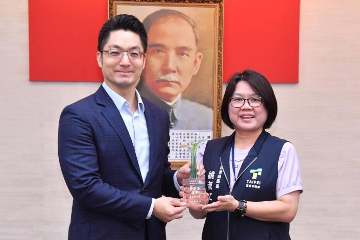 1140610_01_014_頒獻獎_許宜容攝_12樓本府榮獲行政院「第23屆性別平等金馨獎」整體獎優等，請性平辦姚執行長陳獻獎座。