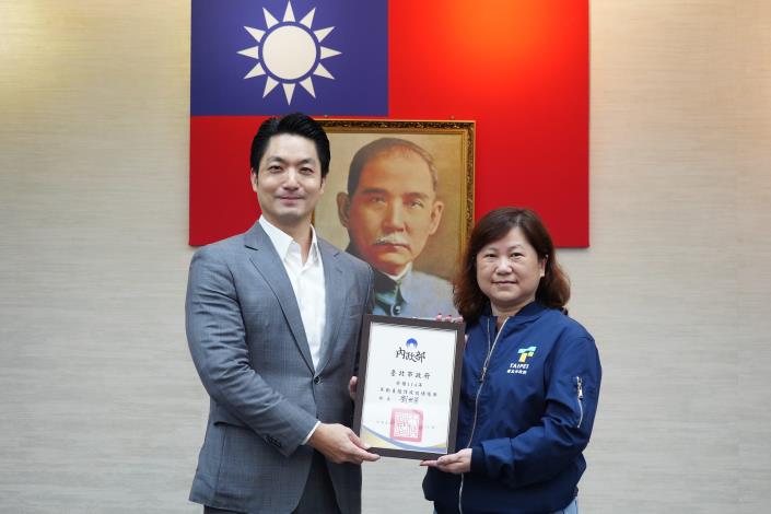 1141125_市政會議頒獻獎_12樓劉銘傳廳_高讚賢攝 (19)本府榮獲內政部「114年不動產阻詐成效」績優獎，請松山地政陳主任陳獻獎狀。.JPG