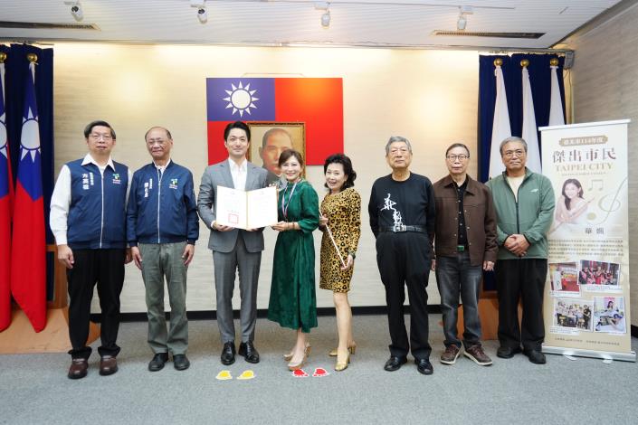 1141125_市政會議頒獻獎_12樓劉銘傳廳_高讚賢攝 (4)表揚本市114年度傑出市民請民政局陳局長、信義區公所方區長及華姵女士親友上台一同合影。.JPG