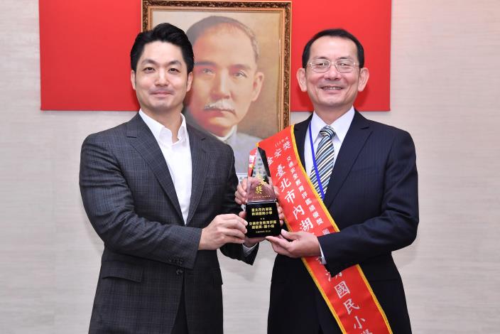 1141209_04_011_獻獎_本市6校榮獲交通部「114年金安獎」_新湖國小郭校長陳獻獎座.JPG