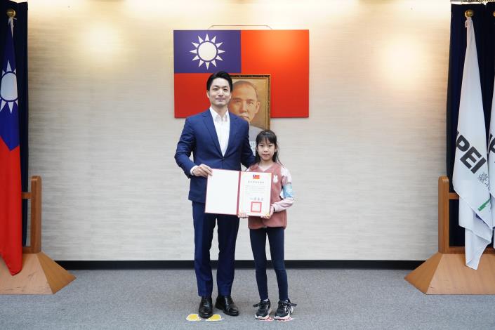 1141223_01(3)_表揚「參加健走趣的我們這一家」繪畫徵選獲選學童，請博愛國小謝婷亦同學上臺受獎。.JPG