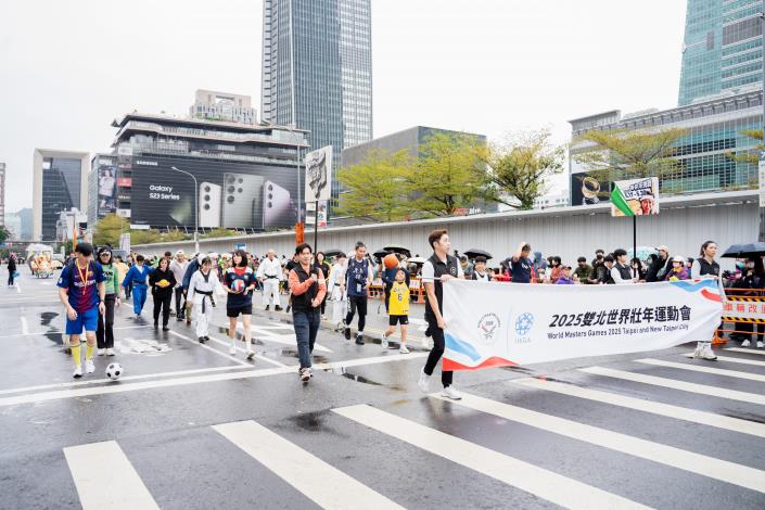 踩街團隊高舉世壯運手舉牌，向民眾宣傳2025雙北世壯運
