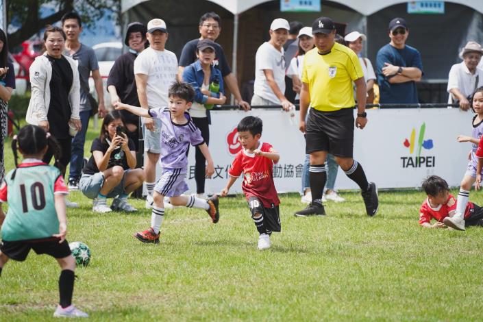 2025年「臺北市幼兒足球錦標賽」週末（17、18日）於道南河濱公園足球場熱鬧開踢，本次共有144支隊伍、近2000名小小足球員參賽，現場還有「臺北熊讚PlayOne女子足球隊」的大姊姊們下場與小選手們同樂，孩子們卯足勁踢球、爸媽們在場邊歡呼吶喊，整座球場洋溢童趣與熱情