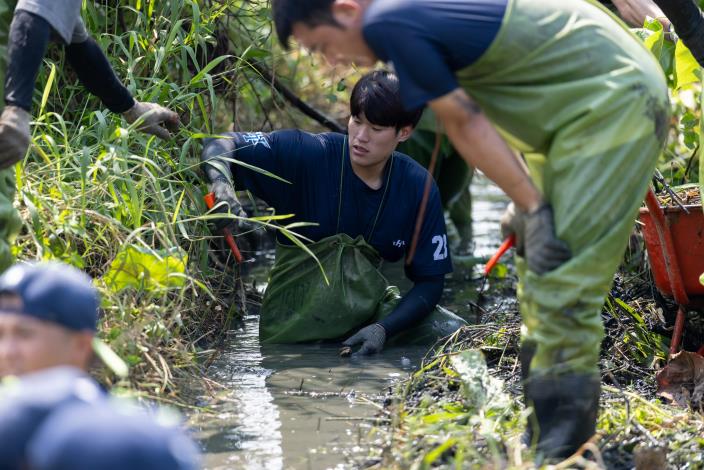 球員們展現球場上的合作默契，一同協助清理濕地水道。