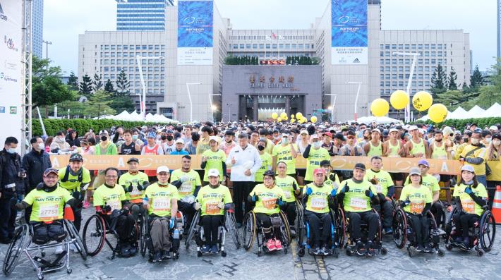 臺北市長柯文哲與輪椅半程馬拉松組選手在起跑拱門前合影。