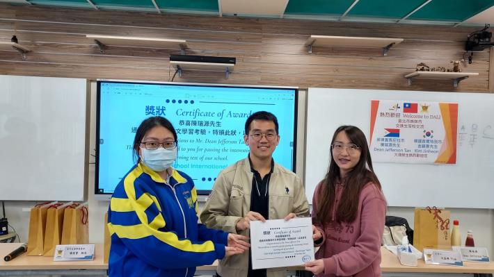 附件7__本校高三國際戰隊成員(左)與駐點老師(右)頒發過關獎狀給來自菲國的陳同學(中)