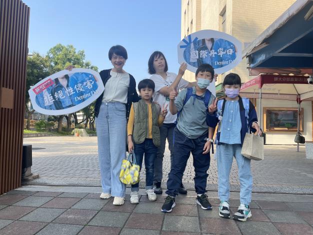 早上學在校門口，家長、校長跟上學的學生穿著牛仔褲一起響應國際單寧日