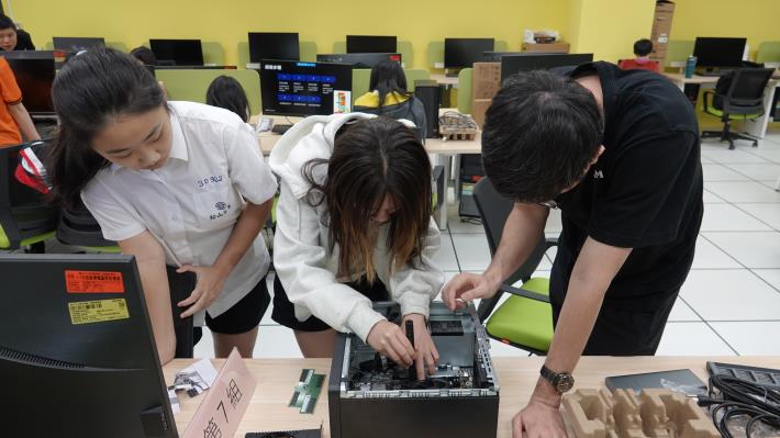 學生仔細安裝主機零件