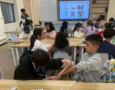 小學員們互相體驗如何操作肌內效貼布使用防止運動傷害