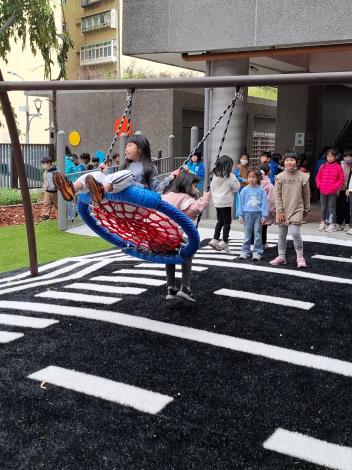 與同學共乘盪鞦韆享受一起玩的樂趣