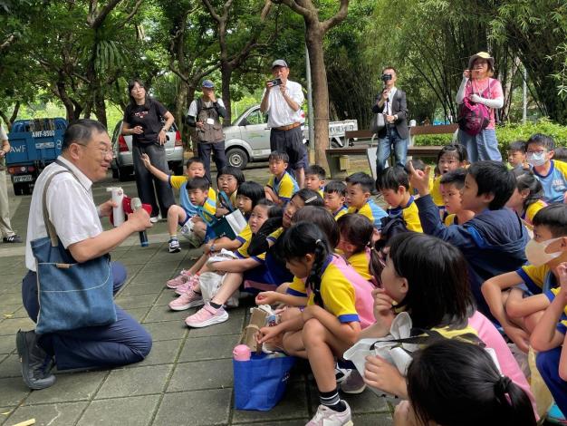 張文亮教授蹲下身與孩子們對談，以生動活潑的方式說明「踩泥」的意義
