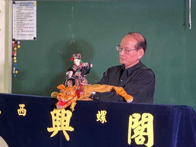 新興閣掌中劇團第六代傳人及現任團長鍾任樑為大家示範經典的武松打虎場景.JPG