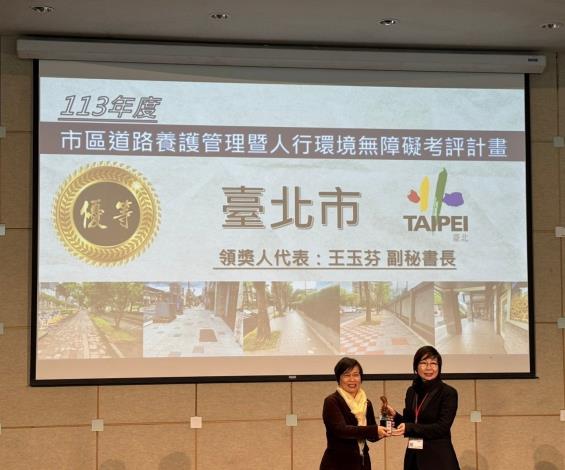 圖1內政部劉世芳部長頒發考評總成績優等獎，臺北市政府王玉芬副秘書長代表受獎