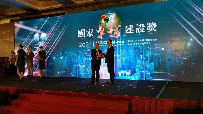 Deputy Director Wang Chien-Chung receiving the award on behalf of the Office (Taipei Municipal Neihu Junior High School Comprehensive Building Project)