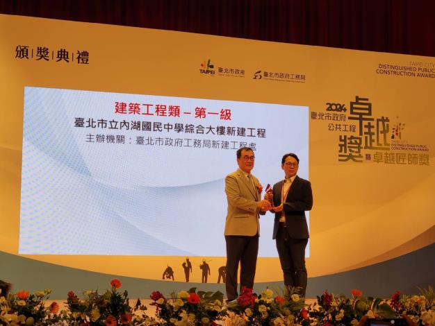 Section Chief Yen Chun-Ming of the Architecture Design Section receiving the award on behalf of the New Construction Office (Taipei Municipal Neihu Junior High School Comprehensive Building Project