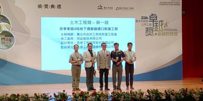 Deputy Chief Engineer Lin Hui-Chung receiving the award on behalf of the New Construction Office and taking a group photo (Zhongxiao East Road Section 4 Underground Pathway Entrance Project)