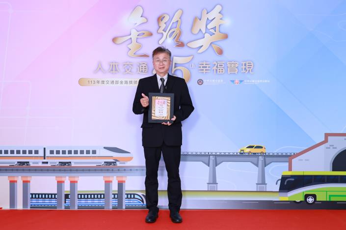 Image 2. Deputy Chief Engineer Chen Ping-lin posing with the Golden Road Award backboard and award plaque