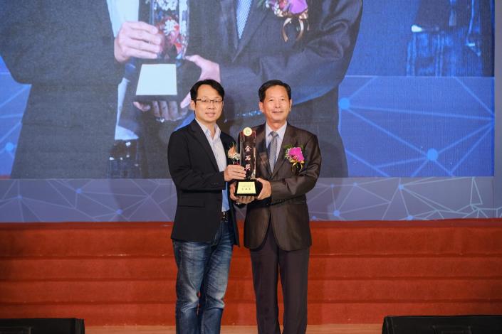 Picture 15. Chief Yen Chun-Ming receives the award (Golden Stone Prize for the XinHu Elementary School Activity Center Project) on behalf of the Office