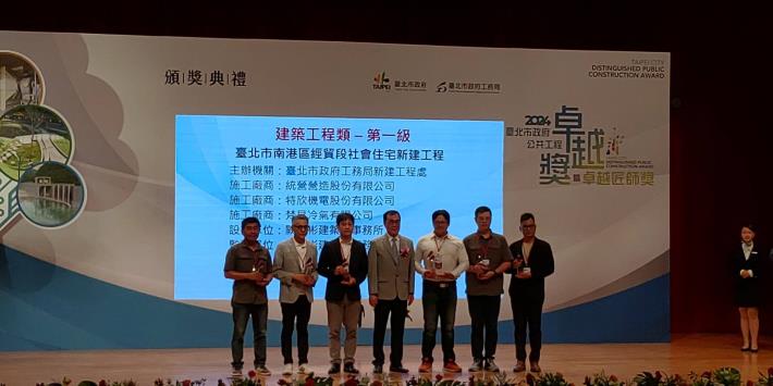 Section Chief Hsiao Chih-Lung receiving the award on behalf of the New Construction Office and taking a group photo (Taipei City Nangang District Jingmao Section Social Housing Project)