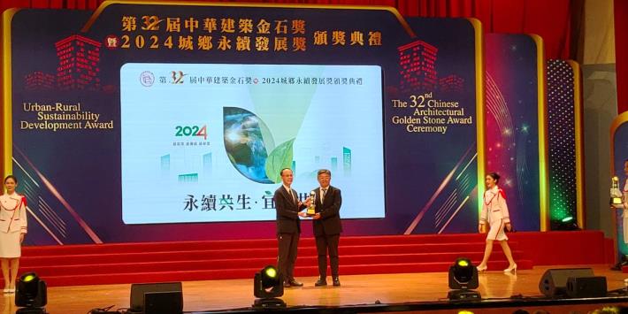 Deputy Director Wang Chien-chung receiving the award on behalf of the New Construction Office (Taipei City Songshan District Xisong Elementary School Activity Center New Construction Project)