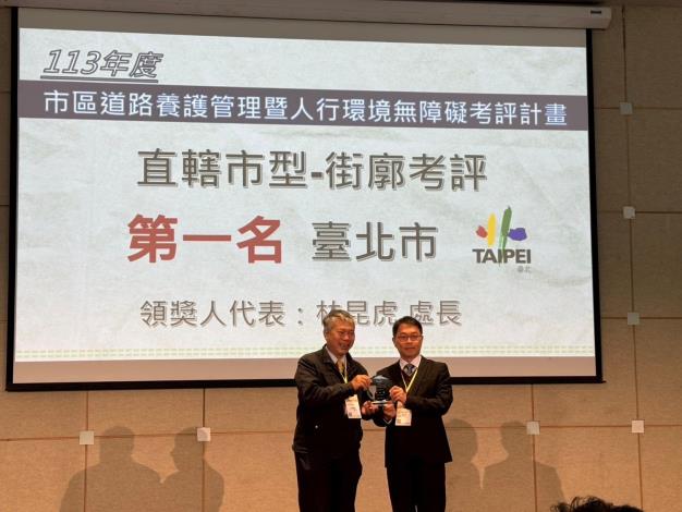 Deputy Chief Engineer Su Chien-lung presents the First Place Award for Street Block Evaluation. Director Lin Kun-hu of Taipei's New Construction Office accepts the award on behalf.