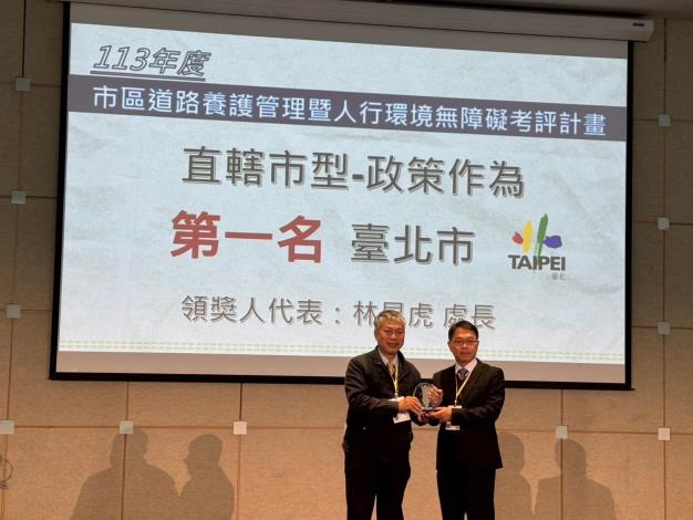 Deputy Chief Engineer Su Chien-lung of the National Land Management Agency, Ministry of the Interior, presents the First Place Award for Policy Evaluation. Director Lin Kun-hu of Taipei's New Construction Office accepts the award on behalf. 