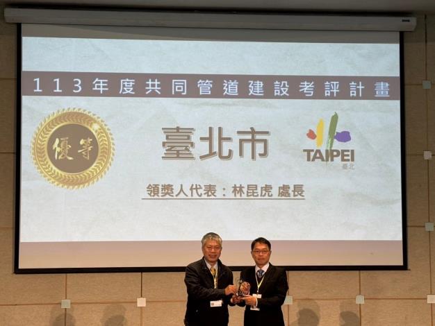 Deputy Chief Engineer Su Chien-lung presents the Outstanding Award for Common Duct Construction Evaluation. Director Lin Kun-hu of the New Construction Office, Public Works Department, Taipei City Government accepts the award on behalf.