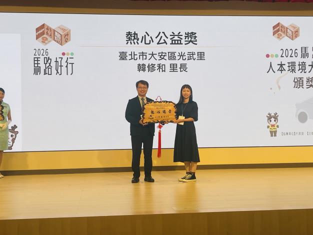Figure 8 Division Director Chi-Hung Chao of the National Land Management Agency, Ministry of the Interior, presents the Public Service Enthusiasm Award, received on behalf of Guangwu Village by Village Officer Chia-Ying Hou