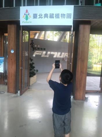 圖1.小朋友下載app後拍攝臺北典藏植物園招牌（莊淳青拍攝）