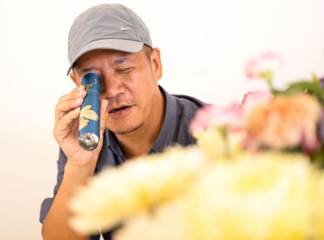 設計師蕭青陽拿起萬花筒，觀察萬花筒裡的花花世界
