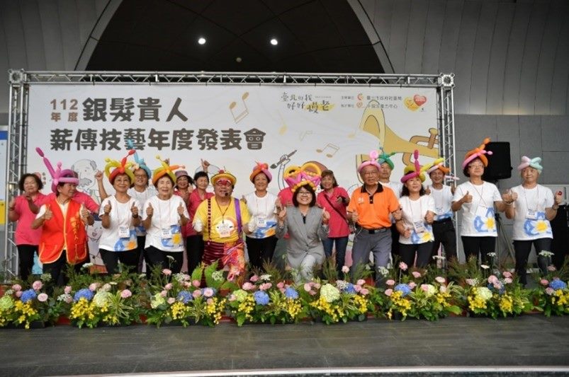Director of the Department of Social Welfare, Taipei City Government, takes a group photo with senior elderly volunteers