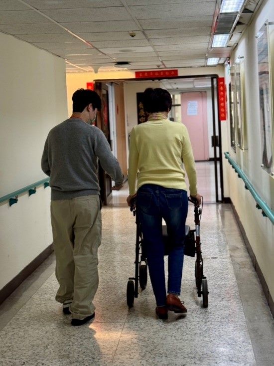 A citizen receiving an assistive device assessment and trying out a walker
