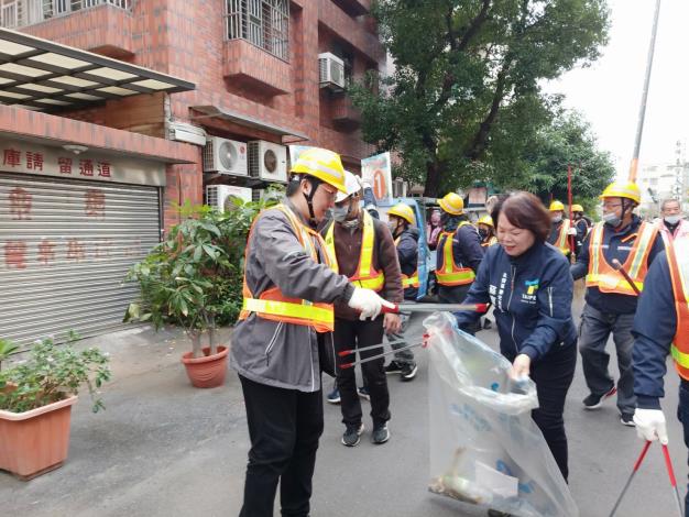 環保局局長徐世勲與榮光里長蘇寶鈴等人也率環保義工們進行環境清潔