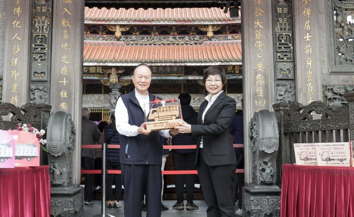 臺北市政府副秘書長王玉芬回贈手工打造檜木資收車模型予龍山寺董事長黃書瑋