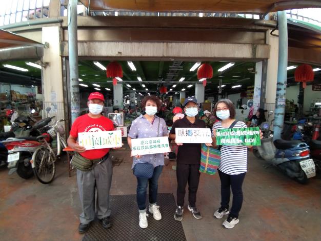 參訪團和太巴塱社區導覽員在光復第一市場前合影。